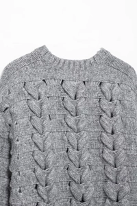 Détail de la texture en maille torsadée grise et de l'encolure du pull en tricot