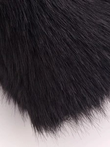Gros plan sur la texture de la fourrure synthétique noire dense d'un gilet d'hiver