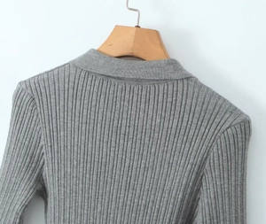 Detail of grey vertical ribbed knit fabric and reinforced collar stitching on dress