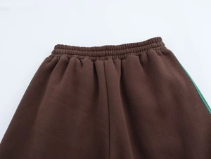 Dettaglio della vita dei pantaloni sportivi marroni con elastico e strisce verdi
