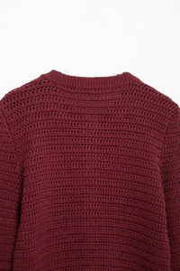 Detailed close-up of dark red textured knit cardigan with round neck and hollow stitching