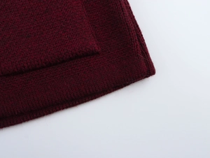 Detailed macro view of the burgundy knitted cardigan with fine ribbing and soft texture