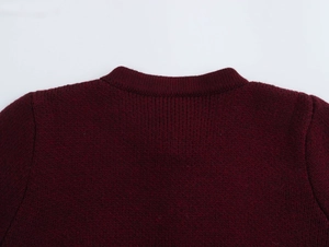 Close-up of the stitching and knitted texture on the burgundy round neck cardigan