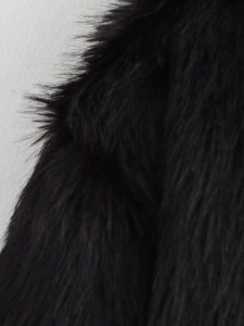 Detailed macro view of high-quality dense black faux fur texture with glossy long fibers