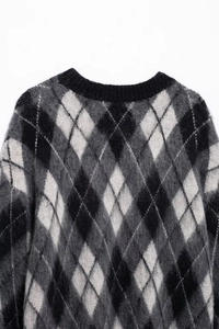 Detail eines weichen Argyle-Strickpullovers mit schwarz-grau-weißer Mohair-Textur