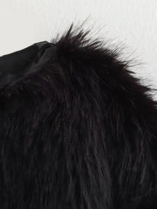Close-up of black faux fur jacket fabric showing dense fibers and satin lining detail