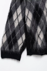 Nahaufnahme der Rautenmuster-Strickjacke mit weicher Mohair-Textur in Grau und Weiß