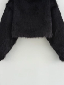 Close-up of black faux fur jacket showing thick plush texture and hemline details