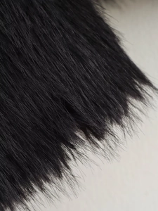 Close-up detail of soft black faux fur texture on a stylish winter jacket for women