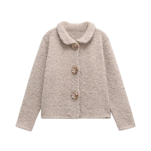 Détail de la veste en polaire avoine avec trois boutons décoratifs en forme de fleurs dorées