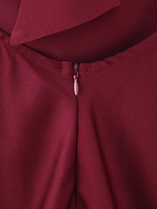 Detailed close-up of seamless invisible zipper on elegant burgundy satin halter dress