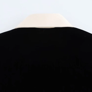 Détail du col contrasté en velours montrant la texture bicolore noir et blanc du tissu