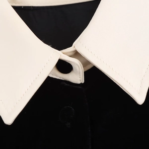 Détail rapproché d'un col en velours contrasté avec coutures nettes et bouton