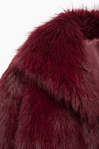 Close-up detail of plush burgundy faux fur collar with premium soft texture and glossy finish
