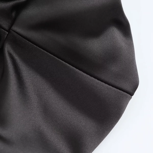 Close-up of black satin dress fabric showing luxurious texture and silky sheen detail