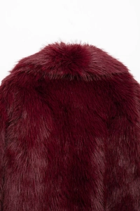 Close-up of soft faux fur texture on a wine red long-sleeved jacket collar and back