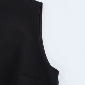 Close-up of precise stitching and seam finish on a black sleeveless dress garment