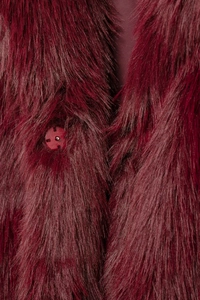 Close-up of wine red faux fur coat showing soft texture and matching round button