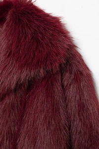Close-up of premium burgundy faux fur coat showing long dense fibers and texture