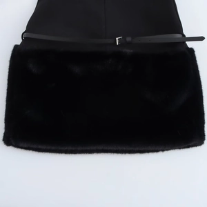 Detail of elegant black dress featuring faux fur hem and slim belt with silver buckle