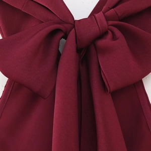 Burgundy satin halter maxi dress featuring a large decorative bow detail on the back