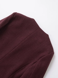 Detail shot of heavy burgundy tweed fabric with premium textured weave for women jacket