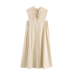 Detail of apricot sleeveless midi dress featuring high neck ties and waist cut-out accents