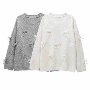 Detail of grey and white knit sweaters featuring 3D diamond patterns and small bows