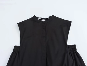 Detail of elegant black sleeveless midi dress with bow tie collar and cut-out shoulders