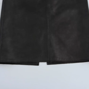 Détail de jupe en similicuir avec coutures verticales fendues et texture de surface lisse