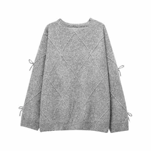 Close-up of gray knit sweater with diamond textures and bow detailing on the long sleeves