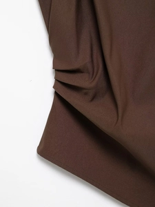 Detail of dark brown twill fabric showing professional stitching and pleated texture