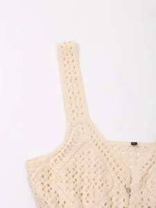Detailed macro view of cream crochet knit camisole with openwork pattern and button