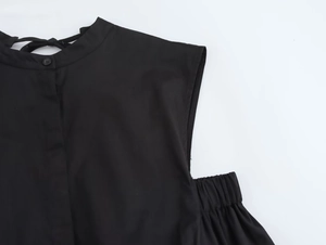 Detail view of black sleeveless midi dress with stand-up collar, buttons and lace-up back