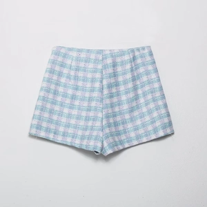 Detailed view of women's tweed shorts with a blue and lilac plaid texture and A-line cut
