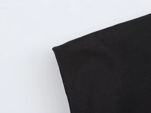 Detail of the high-quality black fabric texture and neat edge stitching on the sleeveless dress