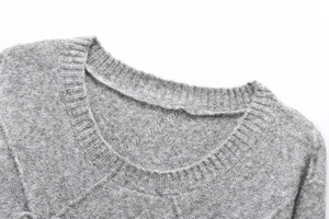 Close-up of ribbed crewneck and soft knitted texture on this grey long sleeve sweater