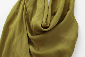 Close-up of olive green cowl neck midi dress showing silky satin fabric and smooth texture