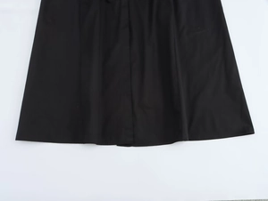 Detail view of black midi dress hemline showing smooth fabric texture and A-line drape