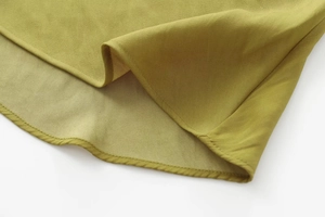 Detail of the olive green midi dress featuring high-quality woven fabric and neat hemline stitching