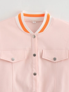 Detail of pink jacket showing ribbed collar, metal buttons, and symmetrical flap pockets