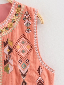 Detailed close-up of coral cotton linen vest showing colorful geometric embroidery patterns
