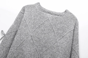 Macro view of grey round neck sweater with classic diamond knit pattern and ribbing