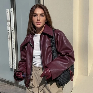 Close-up of deep red faux leather jacket with lapels and silver zipper details