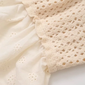 Cream knit camisole top featuring intricate crochet hollow out and floral embroidery detail