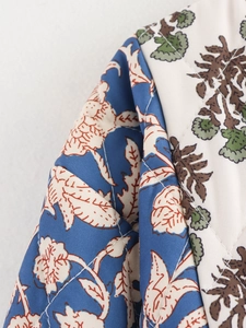 Detailed macro view of diamond-quilted cotton jacket featuring vintage floral patterns