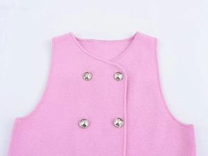 Dettaglio del gilet in maglia rosa con bottoni argentati doppiopetto e trama fine