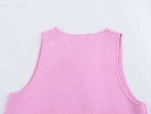 Dettaglio del gilet rosa in maglia con texture raffinata e bordi ben rifiniti
