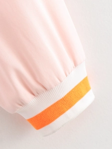 Detail of pink jacket sleeve with white ribbed cuff and orange stripe texture