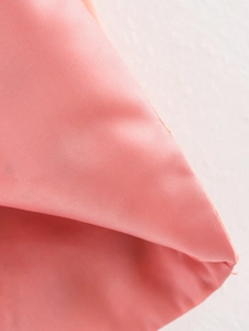 Detailed close-up of the smooth peach-colored inner lining fabric on a summer vest